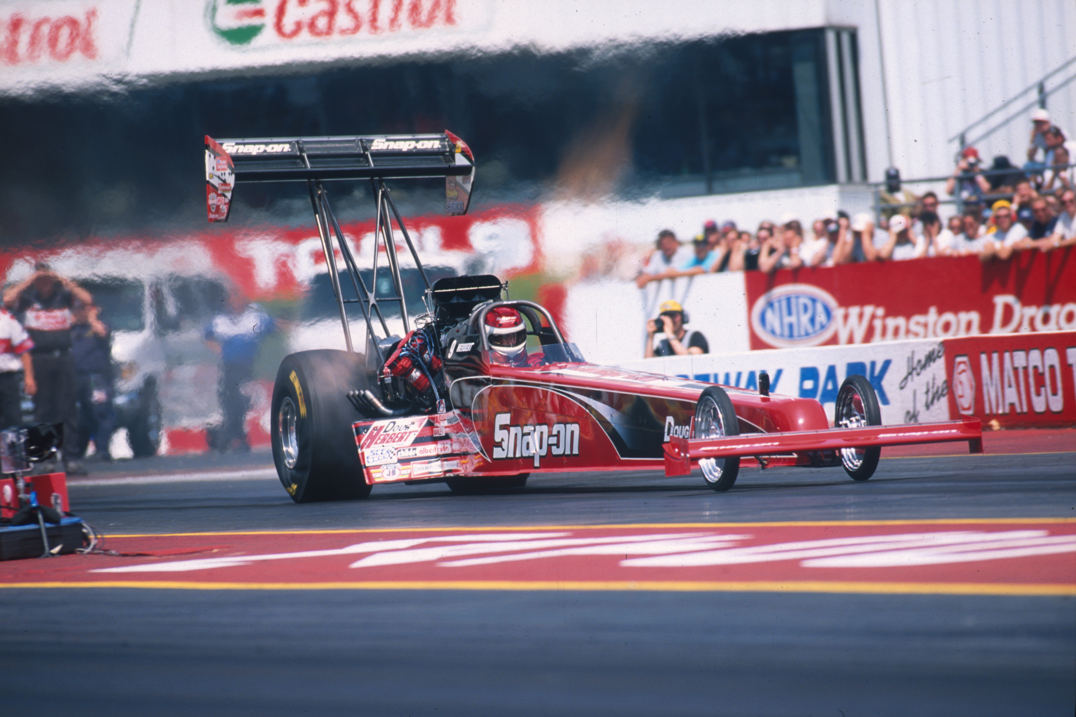 A drag race car moves down the speedway